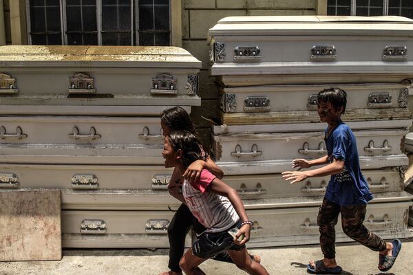 Crianças brincam ao lado de caixões em crematório de Manila
 - Sputnik Brasil