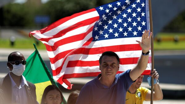 O presidente brasileiro, Jair Bolsonaro, acena em frente a uma bandeira dos Estados Unidos durante protesto pró-intervenção militar em Brasília, em 3 de maio de 2020. - Sputnik Brasil