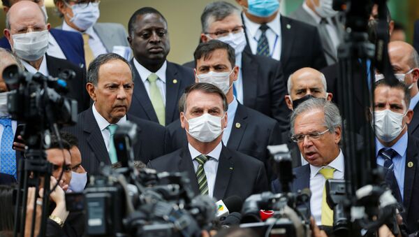 Em Brasília, presidente do Brasil, Jair Bolsonaro, usa máscara ao falar com a imprensa em meio a membros de seu governo após uma reunião com o presidente do Supremo Tribunal Federal (STF), Dias Toffoli. - Sputnik Brasil