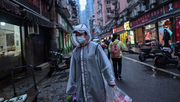 Pedestre levando bolsas de compras em Wuhan, China (foto de arquivo) - Sputnik Brasil