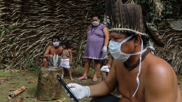 Membros da tribo indígena Saterê Mawé usando máscaras durante atendimento médico via celular com médico em São Paulo na comunidade Sahu-Apé, no município amazonense de Iranduba - Sputnik Brasil