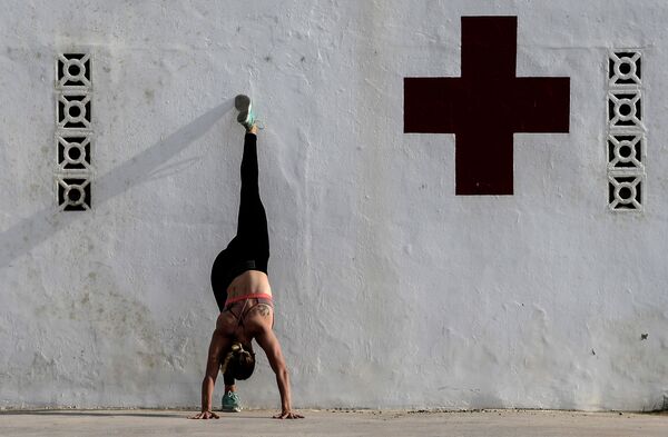 Mulher faz exercícios físicos durante horas permitidas para que a população saia às ruas durante a quarentena em Valência, na Espanha - Sputnik Brasil