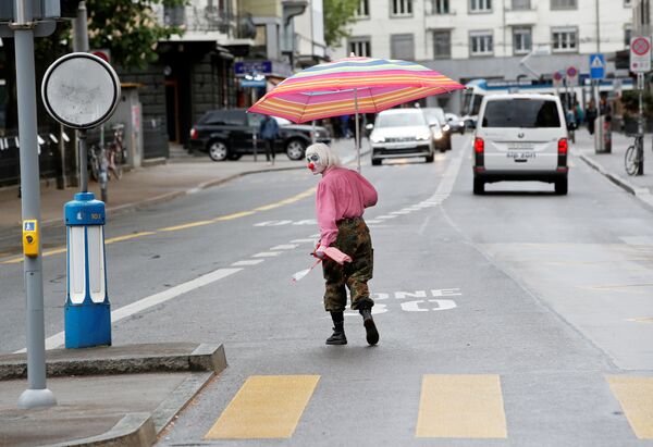 Homem vestido de palhaço atravessa rua de Zurique, na Suíça, durante a propagação da COVID-19 - Sputnik Brasil