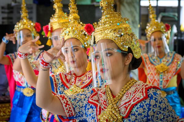 Dançarinas tailandesas usam escudos faciais durante apresentação no templo de Erawan Shrine, na Tailândia - Sputnik Brasil