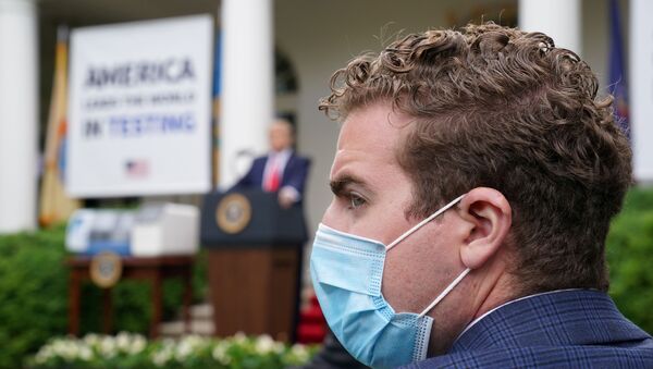 Repórter com máscara protetora durante conferência de imprensa do presidente dos EUA, Donald Trump, na Casa Branca, em Washington, 11 de maio de 2020 - Sputnik Brasil