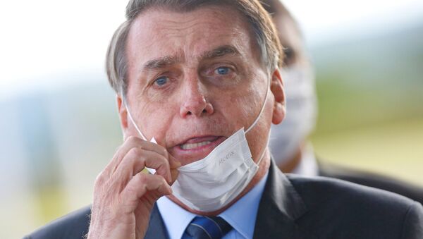 Presidente do Brasil, Jair Bolsonaro, ajusta sua máscara ao deixar o Palácio da Alvorada, em Brasília, 13 de maio de 2020 - Sputnik Brasil