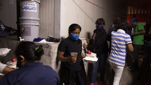 Moradores de rua e desempregados com máscaras recebem alimentos em meio à pandemia do coronavírus na Guatemala - Sputnik Brasil
