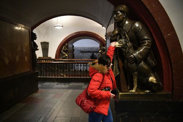 Moça faz tradicional toque em focinho de cachorro, uma estátua na estação Ploschad Revolyutsy do metrô de Moscou - Sputnik Brasil