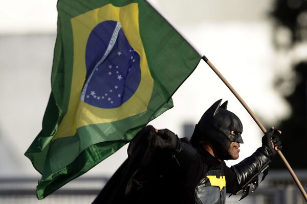 Homem vestido com traje de Batman e segurando bandeira nacional junta-se a multidão em frente ao Palácio do Planalto, demonstrando seu apoio ao presidente Jair Bolsonaro. - Sputnik Brasil