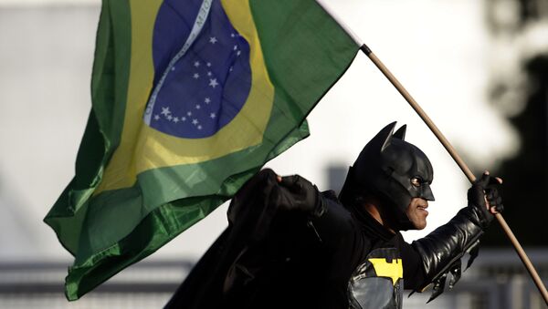 Homem vestido com traje de Batman e segurando bandeira nacional junta-se a multidão em frente ao Palácio do Planalto, demonstrando seu apoio ao presidente Jair Bolsonaro - Sputnik Brasil