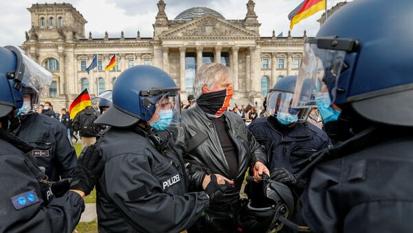 Em frente ao Reichstag, em Berlim, policiais com máscaras detém um manifestante que protestava contra as medidas de isolamento social na Alemanha durante a pandemia da COVID-19. - Sputnik Brasil