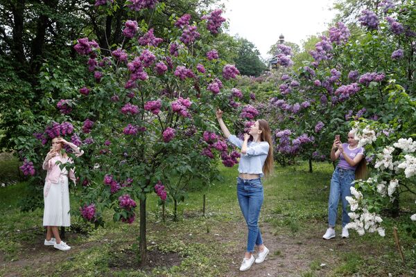 Mulheres tiram fotos em frente a flores em jardim botânico em Kiev, na Ucrânia, 18 de maio de 2020 - Sputnik Brasil