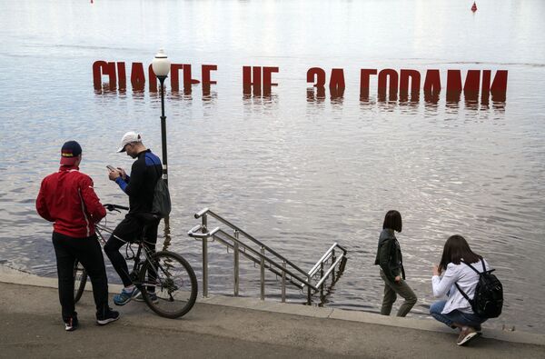 Residentes da cidade russa de Perm tiram foto perto de objeto de arte inundado após subida do nível da água no rio Kama - Sputnik Brasil