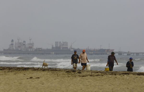 Pescadores venezuelanos caminham na costa com o petroleiro iraniano Fortune no horizonte - Sputnik Brasil