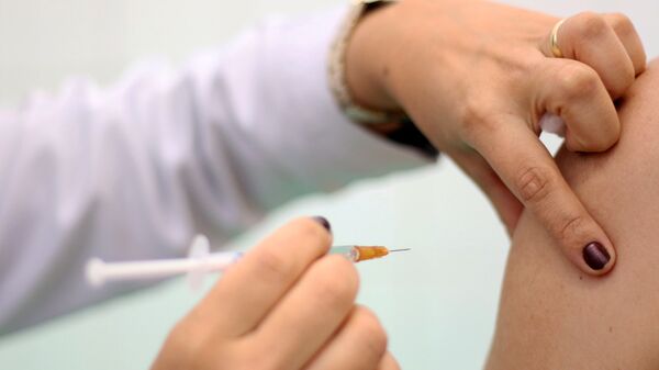 Enfermeira aplica vacina contra gripe em unidade do Sistema Único de Saúde (SUS). - Sputnik Brasil