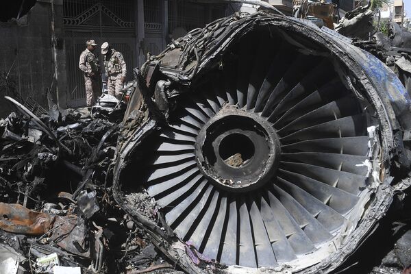 Agentes de segurança ao lado de destroços de aeronave Airbus 320 das Linhas Aéreas Paquistanesas que caiu em Carachi - Sputnik Brasil