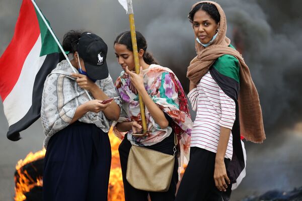 Mulheres levantam bandeiras durante ato em Cartum, no Sudão - Sputnik Brasil