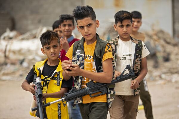 Crianças iraquianas brincam com armas de plástico durante o feriado islâmico de Eid al-Fitr, no fim do Ramadã, na cidade iraquiana de Basra - Sputnik Brasil