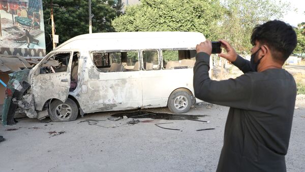 Um homem fotografa um veículo que foi atacado enquanto carregava funcionários de uma emissora em Cabul, no Afeganistão, em 30 de maio de 2020. - Sputnik Brasil