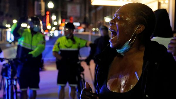 Manifestante reage após ser atingida por agente químico usado pela polícia para conter protestos em Boston, Massachusetts, EUA, 31 de maio de 2020 - Sputnik Brasil