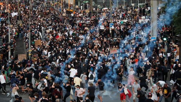 Em Paris, manifestantes fogem de gás lacrimogênio lançado pela polícia durante protesto antirracista, em 2 de junho de 2020, pedindo justiça pela morte de Adama Traore. - Sputnik Brasil