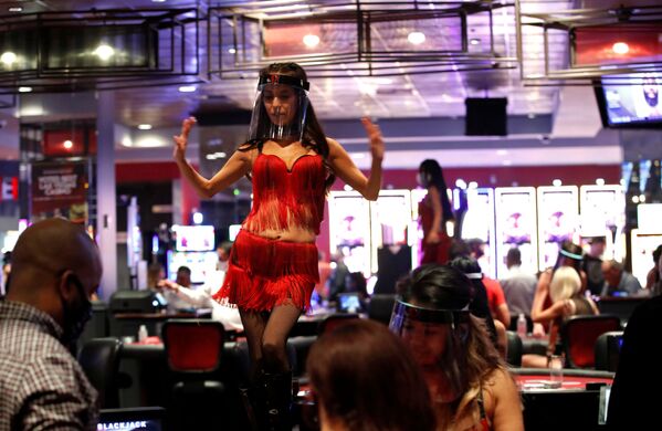 Mulher usa escudo facial enquanto dança durante a reabertura de casino em Las Vegas, fechado devido à pandemia nos EUA - Sputnik Brasil