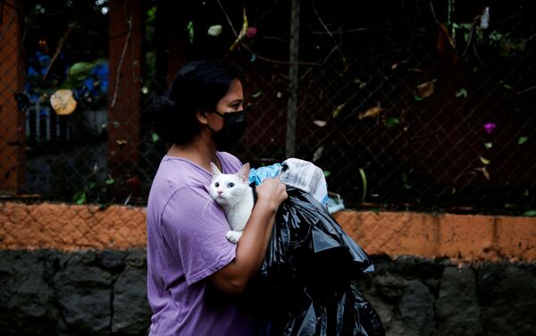 Mulher usando máscara facial segura gato durante as inundações causadas pela tempestade tropical Amanda, em Ilopango, El Salvador, 31 de maio de 2020 - Sputnik Brasil