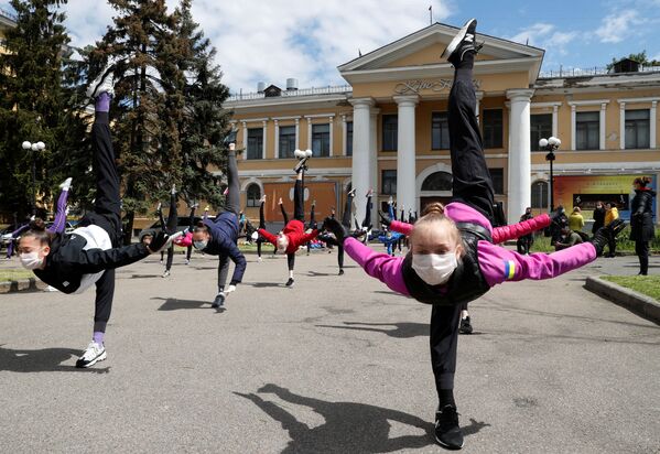 Alunos de escola de ginástica rítmica, usando máscaras e luvas, participam de uma sessão de treinamento ao ar livre em Kiev, Ucrânia - Sputnik Brasil