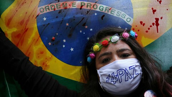 Manifestante carrega bandeira do Brasil manchada, durante protesto contra o governo Bolsonaro, em Porto Alegre, 7 de junho de 2020 - Sputnik Brasil