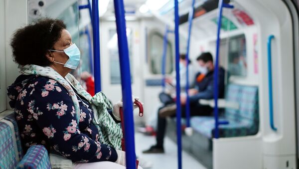 Mulher usando uma máscara facial em um trem do metrô de Londres durante a pandemia de COVID-19 - Sputnik Brasil