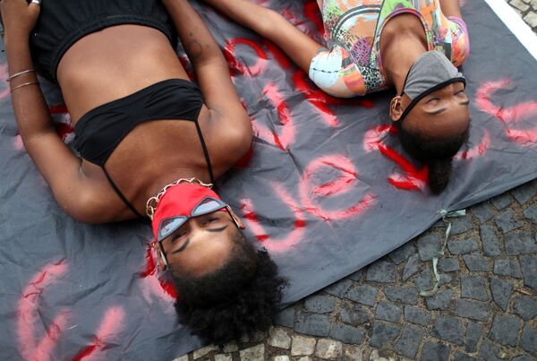 Meninas deitam em uma calçada de Copacabana com máscaras de proteção em meio a protestos pela democracia - Sputnik Brasil