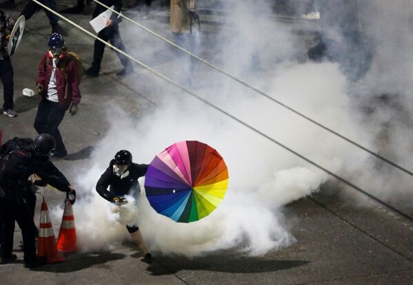 Participante de manifestação contra a morte do cidadão George Floyd leva guarda-chuva com as cores do arco-íris - Sputnik Brasil