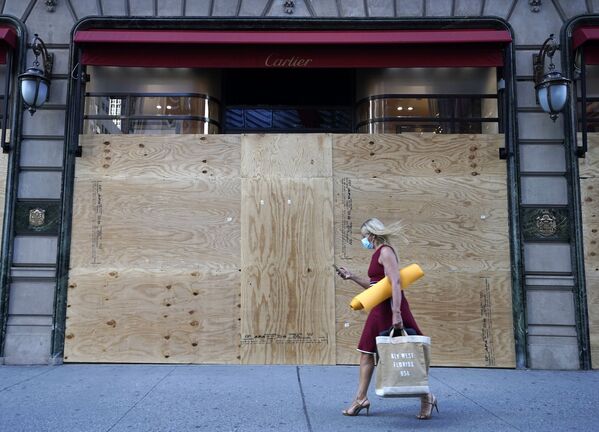 Mulher passa em frente de loja de joias e relógios Cartier, fechada com estrutura especial em Nova York, enquanto cidade recomeça a retomar atividades comerciais no contexto da pandemia - Sputnik Brasil