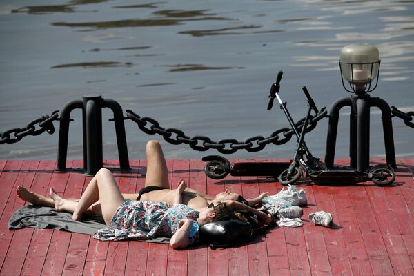 Casal toma banho de sol no Parque Gorky no centro de Moscou durante o verão na capital russa - Sputnik Brasil