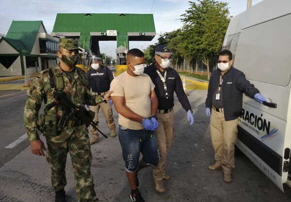Agentes da Migração Colômbia conduzindo o alegado militar venezuelano Gerardo José Rojas Castillo durante sua expulsão do país após suspeita de espionar para a Venezuela - Sputnik Brasil