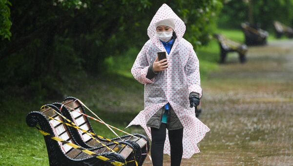 Menina, envergando máscara e e capa de chuva, passeando pelo Parque Kolomenskoye, em Moscou, Rússia - Sputnik Brasil