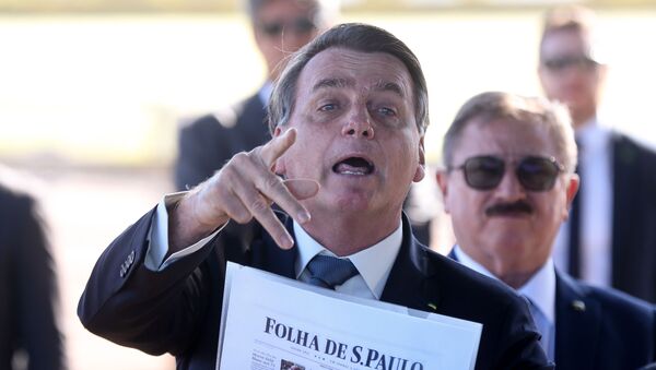Presidente Jair Bolsonaro fala com a imprensa ao sair do Palácio da Alvorada, em Brasília, segurando um exemplar da Folha de S.Paulo - Sputnik Brasil