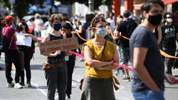 Em Berlim, manifestante segura uma placa com a frase, em alemão, racismo é a pior pandemia, durante protesto antirracista em 13 de junho de 2020. - Sputnik Brasil