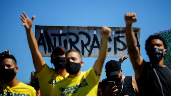 Em Brasília, manifestantes antirracistas levantam os punhos durante protesto contra o presidente Jair Bolsonaro, em 21 de junho de 2020. - Sputnik Brasil