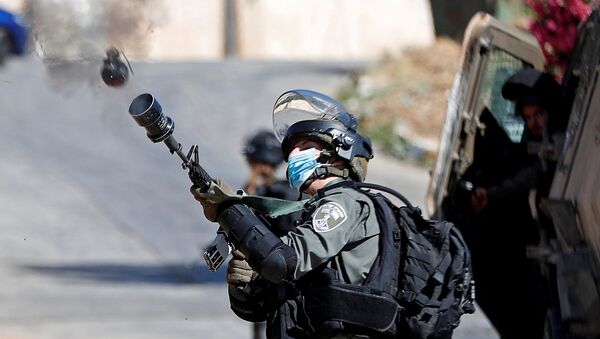 Soldado israelense atira gás lacrimogênio em manifestantes que protestavam contra a demolição de uma casa palestina na Cisjordânia ocupada, 24 de junho de 2020 - Sputnik Brasil