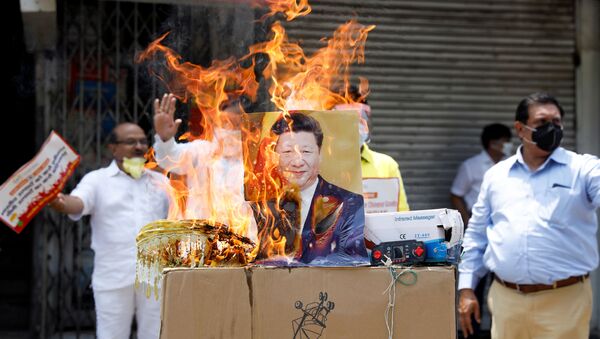 Manifestantes queimam produtos fabricados na China e um pôster do presidente chinês Xi Jinping durante protesto contra a China, em Nova Deli, na Índia, em 22 de junho de 2020 - Sputnik Brasil