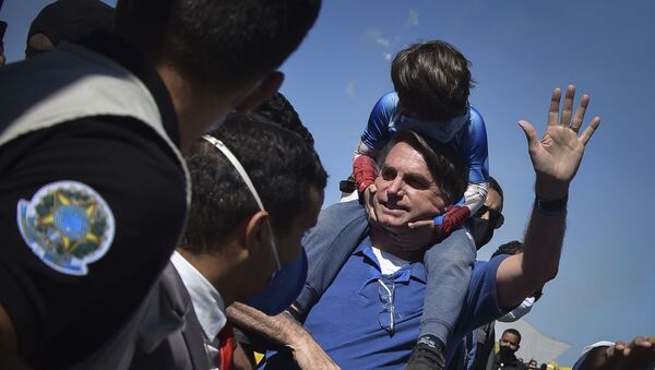 Presidente Jair Bolsonaro carrega uma criança em suas costas em ato a favor do seu governo em Brasília - Sputnik Brasil