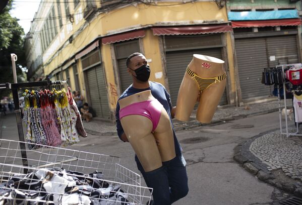 Vendedor com máscara protetora leva manequins no mercado de rua no Rio de Janeiro - Sputnik Brasil