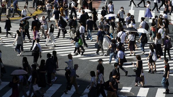 Pessoas usando máscaras faciais protetoras para ajudar a conter a propagação do coronavírus em Tóquio, Japão - Sputnik Brasil