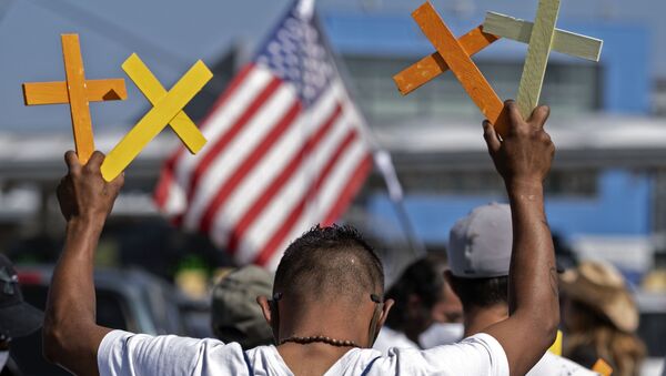 Imigrante deportado dos EUA segura cruzes na cidade mexicana de Tijuana, na fronteira entre EUA e México, 8 de julho de 2020 - Sputnik Brasil