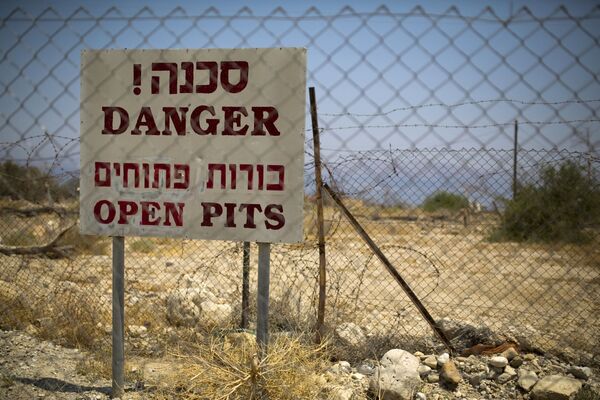 Placa sinalizando o perigo de sumidouros em um resort turístico abandonado na costa do mar Morto, em Israel - Sputnik Brasil
