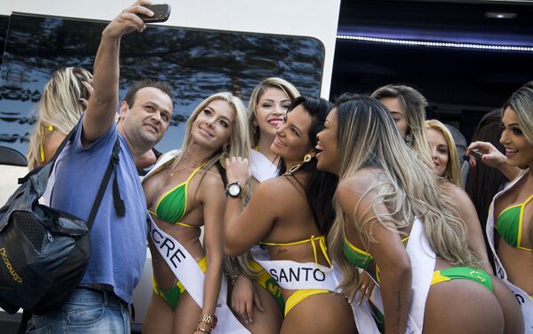 Um homem tira selfie com participantes do concurso Miss Bumbum Brazil 2015 em São Paulo - Sputnik Brasil