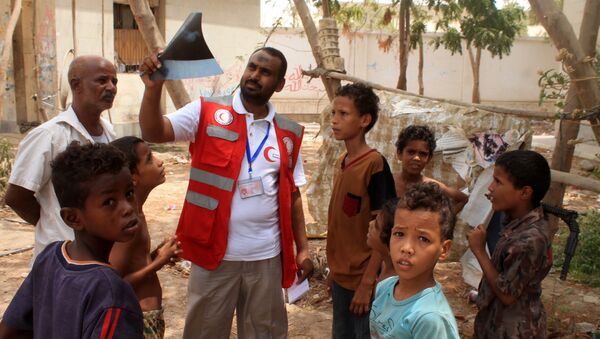Um representante da Cruz Vermelha com um grupo de crianças iemenitas evacuadas na cidade portuária de Aden, no sul do país - Sputnik Brasil