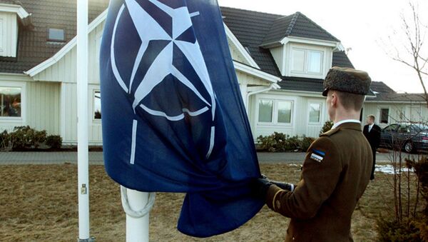 Soldado estoniano iça a bandeira da OTAN em frente da casa do ex-presidente da Estônia, Lennart Meri, na cidade de Tallinn. 29 de março de 2004. - Sputnik Brasil
