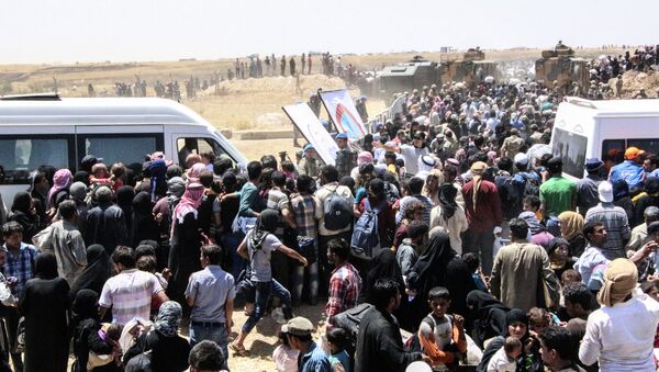 Refugiados sírios estão à espera de transporte após atravessar a fronteira com a Turquia da cidade síria Tal Abyad, em 10 de junho de 2015 - Sputnik Brasil